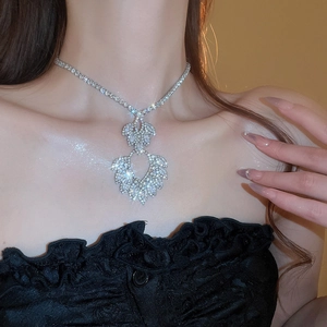 Close-up of sparkling leaf-shaped diamond necklace worn by a model for evening events