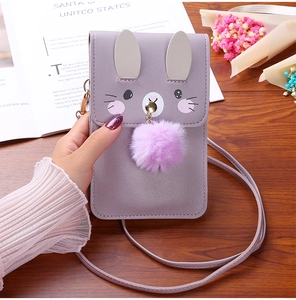 Detail of purple rabbit-shaped phone bag with soft plush ball and slender strap