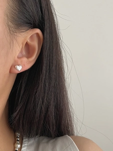 Close-up of S925 sterling silver heart stud earrings with vertical textured stripes