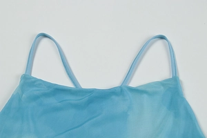 Détail du tissu en maille transparente avec un dégradé bleu clair sur le caraco