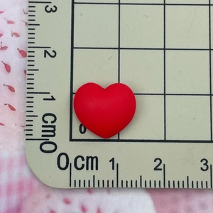 Mini cœur en résine mate rouge mesuré avec règle pour DIY nail art et bijoux