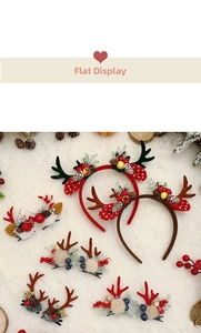 Close-up of Christmas reindeer antler headbands with pine cones and berries on snow