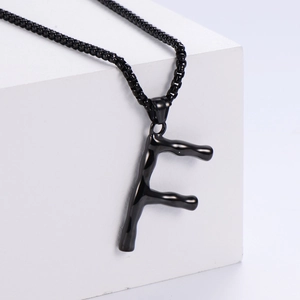 Vista dettagliata della collana con pendente lettera F in finitura metallo nero lucido