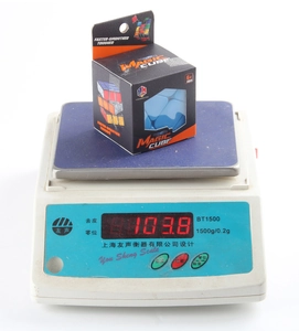 Digital scale measuring the 103.8g weight of a blue speed magic cube in packaging