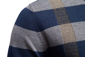 Vue macro détaillée de la couture d'épaule d'un pull en maille rayé tricolore aux points fins