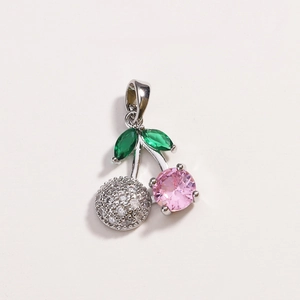 Dettaglio del ciondolo a ciliegia in argento con pietre di zircone rosa e verdi su bianco