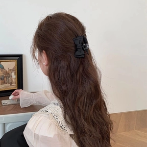 Pince à cheveux élégante avec nœud noir sur cheveux longs bouclés, style princesse