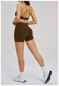 Close-up of brown cross-waist yoga shorts and strappy sports bra on a back view model