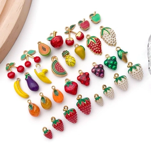 Flat lay of colorful fruit enamel pendants like strawberry and banana for DIY jewelry