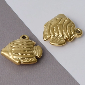Detailed macro view of 18k gold plated stainless steel fish charms with embossed texture