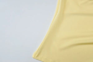 Dettaglio ravvicinato del tessuto a maglia giallo chiaro con trama fine e cucitura dell'orlo