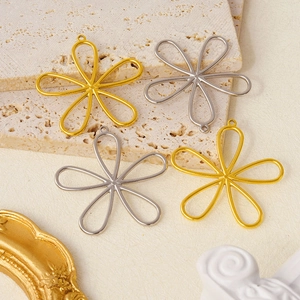 Detailed view of hollow flower pendants in gold and silver steel for DIY jewelry making
