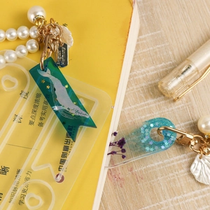 Detailed shot of whale pendant mold with acrylic charms and elegant pearl chain decor