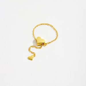 Detail shot of a gold S925 sterling silver chain ring with double heart charms on white