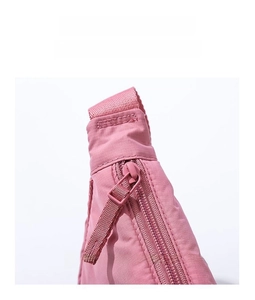 Close-up of brand custom zipper and durable nylon texture on pink crossbody bag