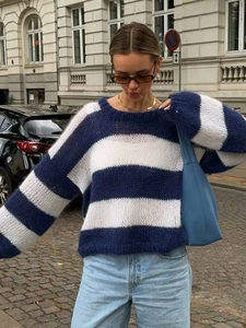 Close-up of women's blue and white striped knit sweater with round neck and loose fit