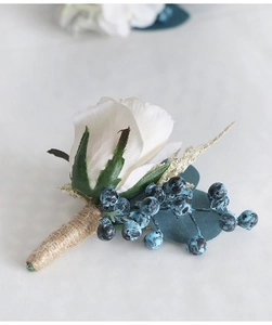 Detail of white boutonniere with dark blue berries and rustic twine handle wrapping