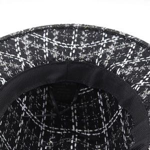 Detail view of houndstooth wool fedora interior showing sweatband and material label