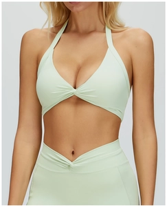 Detail of mint green halter yoga bra with front twist knot and high waist leggings