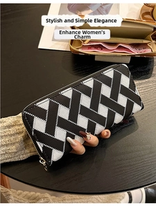 Macro view of long zipper wallet with black and white geometric pattern and gold hardware