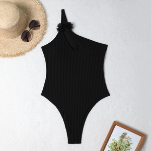 Close-up of ribbed black one-piece swimsuit featuring elegant 3D floral shoulder detail