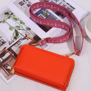 Orange leather crossbody bag with pink purple ethnic woven wide shoulder strap on magazines