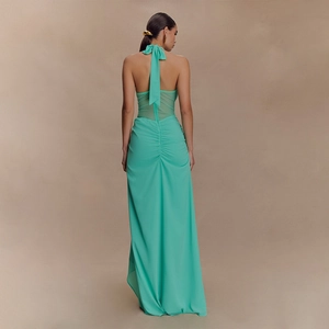 Detail of green halter dress featuring an open back and elegant ribbon bow tie design