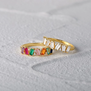 Macro shot of gold S925 silver rings with colorful rectangular gems and round diamonds