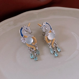 Macro view of unicorn earrings with blue teardrop gems and white cubic zirconia stones