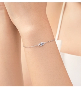 Silver evil eye bracelet featuring a blue gemstone center and clear pavé crystals