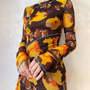 Détail de la robe en tulle transparent avec imprimé floral orange et couture bleue contrastée