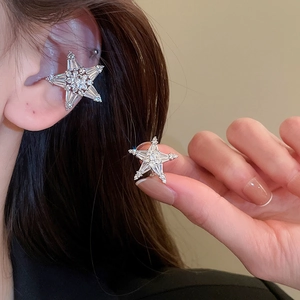Detailed view of silver star ear cuff with sparkling zircon inlay worn by model