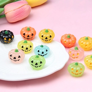 Colorful resin mini luminous Halloween pumpkins with carved faces on a white plate