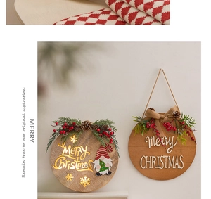 Detail of wooden Merry Christmas hanging sign with pine needles and warm LED lighting