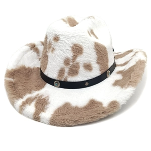 Close-up of cow print plush cowboy hat featuring a leather band and turquoise studs