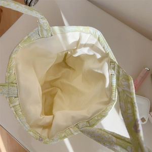 Detail shot of the spacious interior lining and floral quilted fabric of the tote bag