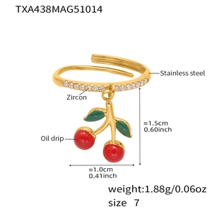 Detailed macro view of cherry charm ring with red enamel and zircon on gold steel