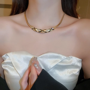 Detail of gold snake chain necklace with black enamel and pave rhinestone pendant on neck