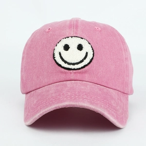 Close-up of vintage pink washed cotton baseball cap with fuzzy smiley face embroidery