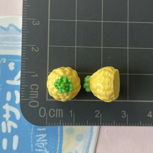 Dettaglio macro di mini ciondoli a forma di ananas in resina per accessori fai-da-te