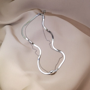 Detail of silver double-layered snake chain with metallic cylindrical bead pendant