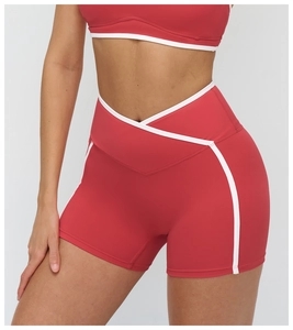 Détail du short de yoga rouge à taille haute croisée en V et liseré blanc contrastant
