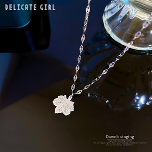 Detailed macro view of a silver hollow maple leaf pendant on a fine metal chain necklace