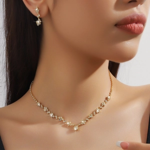 Dettaglio del set di gioielli da sposa dorati con zirconi su una modella elegante