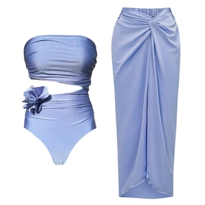 Three-piece periwinkle blue swimwear set with 3D floral details and wrap skirt