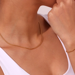 Detail of 18K gold plated stainless steel box chain necklace and bracelet on model