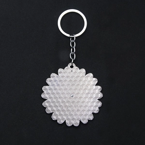 Macro view of metallic flower keychain back with textured hexagonal honeycomb pattern