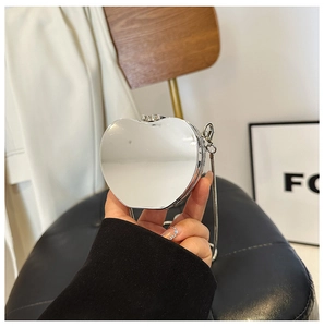 Close-up of a silver apple-shaped acrylic evening bag with a sleek metal chain strap