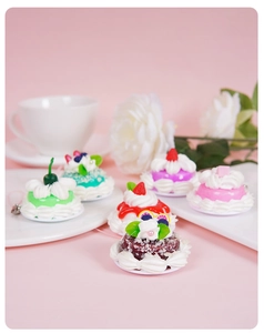Detailed view of artificial mini cake charms with creamy textures and fruit toppings