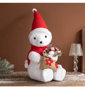 Detail of Christmas polar bear plush with red scarf and hat holding a pine cone burlap bag